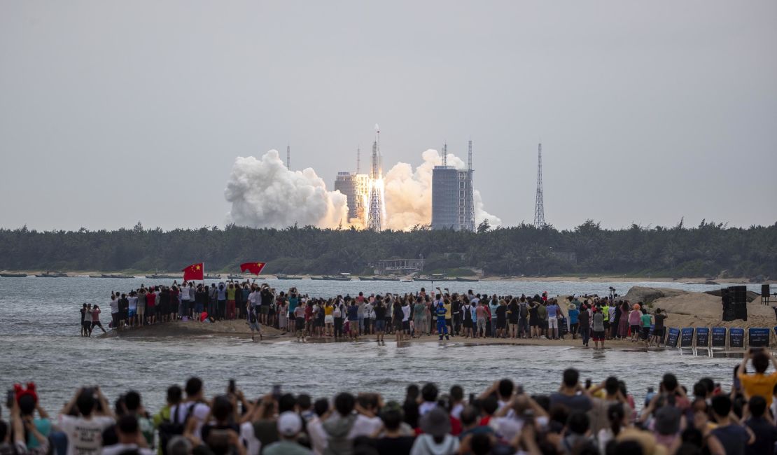 People watch as the Long March-5B carrier rocket blasted off from the Wenchang Space Launch Center in Hainan Province, carrying the space stationcore module on Tuesday. 