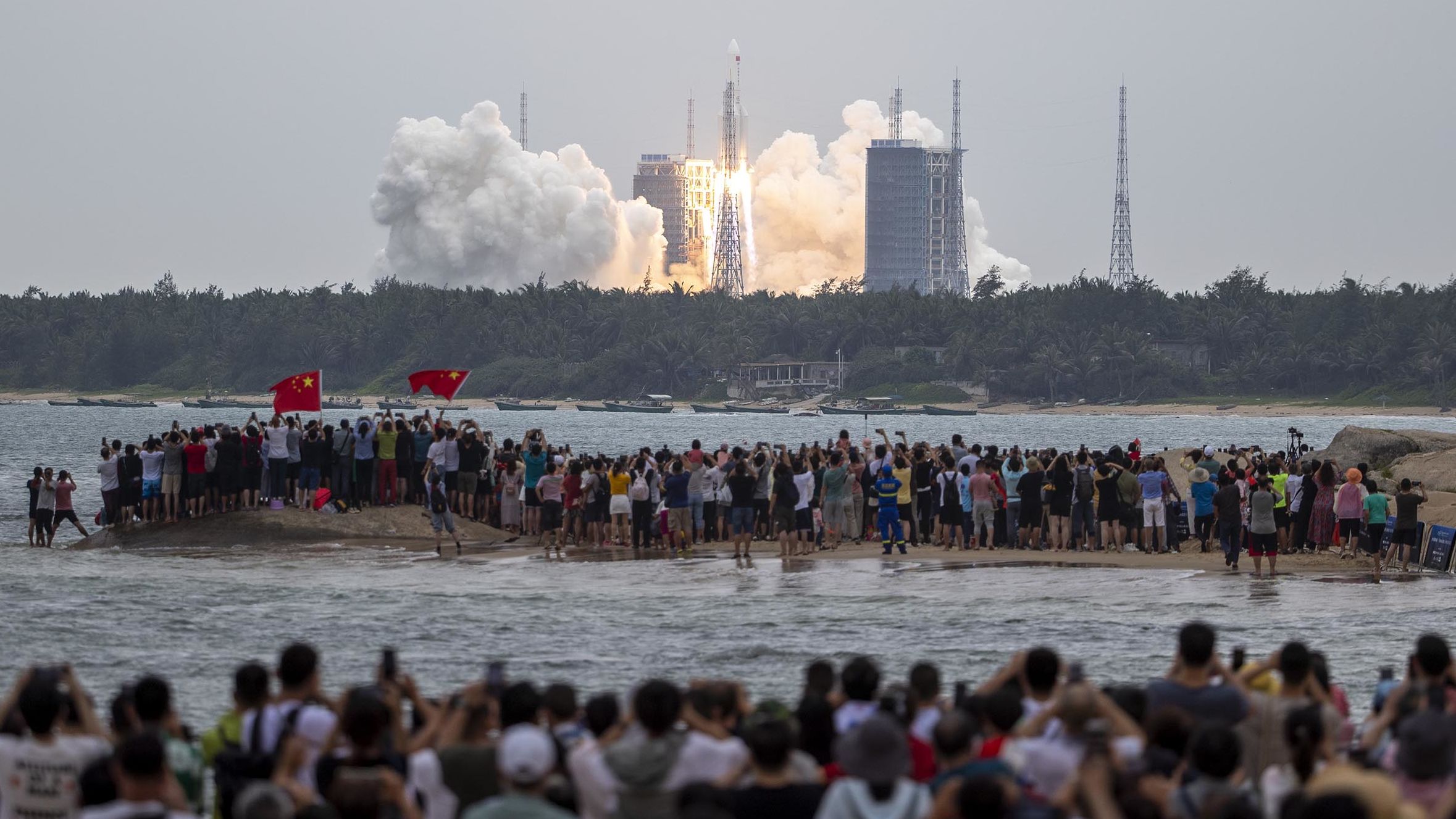 People watch as the Long March-5B carrier rocket blasted off from the Wenchang Space Launch Center in Hainan Province, carrying the space stationcore module on Tuesday. 