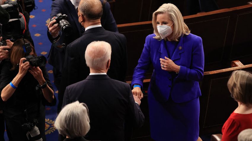 US President Joe Biden (C) greets Rep. Liz Cheney (R-WY) with a fist bump before addressing a joint session of congress in the House chamber of the US Capitol April 28, 2021 in Washington, DC.
