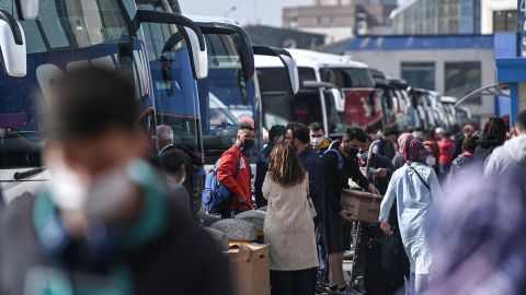 Travelers wait to board coaches as they prepare to leave the city from the Esenler national bus station in Istanbul on Thursday, just hours ahead of a national lockdown set to last for three weeks. 