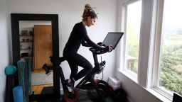 Cari Gundee rides her Peloton exercise bike at her home on April 06, 2020 in San Anselmo, California.  More people are turning to Peloton due to shelter-in-place orders because of the coronavirus (COVID-19). Peloton stock has continued to rise over recent weeks even as most of the stock market has plummeted. However, Peloton announced today that they will temporarily pause all live classes until the end of April because an employee tested positive for COVID-19.  (Photo by Ezra Shaw/Getty Images)