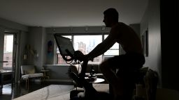 NEW YORK, NY - MAY 18: Justin Wiezel works out on a Peloton high-tech stationary bike in his apartment on May 18, 2020 in New York City. Coronavirus temporarily shut down schools and gyms, substantially increasing online education and at-home exercise routines. (Photo by Michael Loccisano/Getty Images)