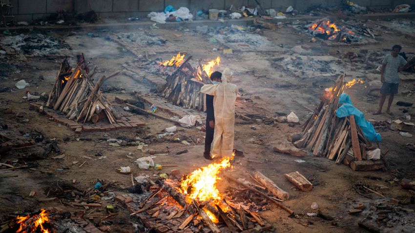 Family members embrace each other amid burning pyres of victims who lost their lives due to the Covid-19 coronavirus at a cremation ground in New Delhi on April 26, 2021.