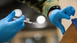 A member of the U.S. armed forces administers a dose of the Pfizer Covid-19 vaccine at a FEMA community vaccination center in this file photo taken in March in Philadelphia.
