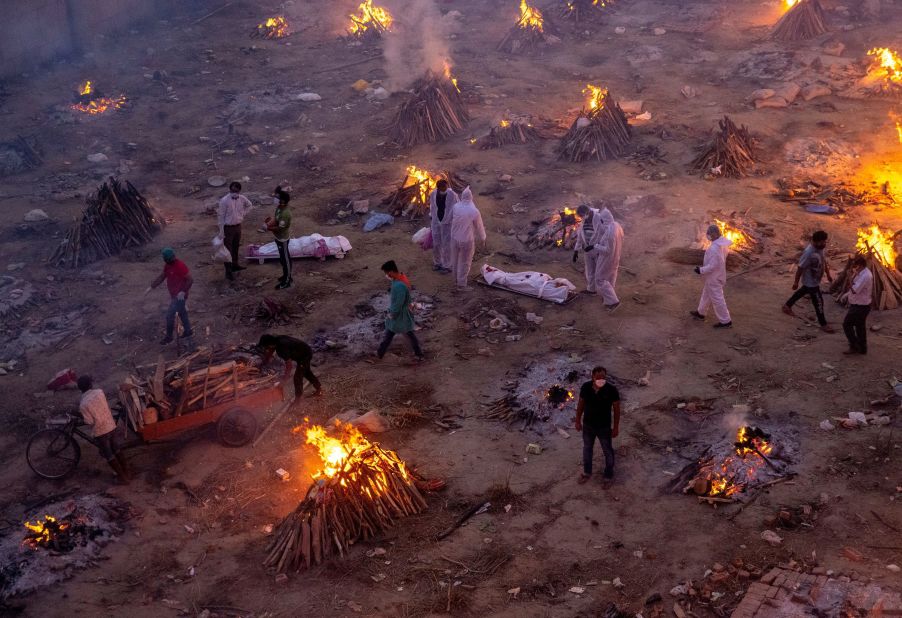 Funeral pyres burn in New Delhi as people wait to cremate Covid-19 victims on April 23. A second wave of Covid-19 <a href="index.php?page=&url=http%3A%2F%2Fwww.cnn.com%2F2021%2F04%2F26%2Findia%2Fgallery%2Findia-coronavirus-crisis%2Findex.html" target="_blank">is devastating India,</a> killing thousands of people each day and setting world records for daily infections.