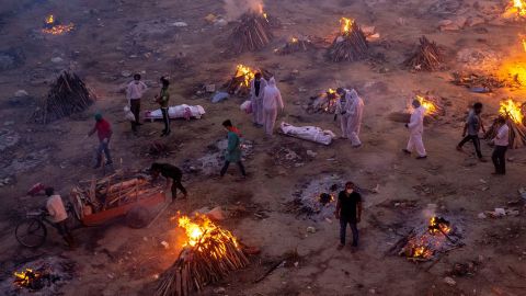 People wait to cremate bodies at a crematorium ground in New Delhi on April 23. 