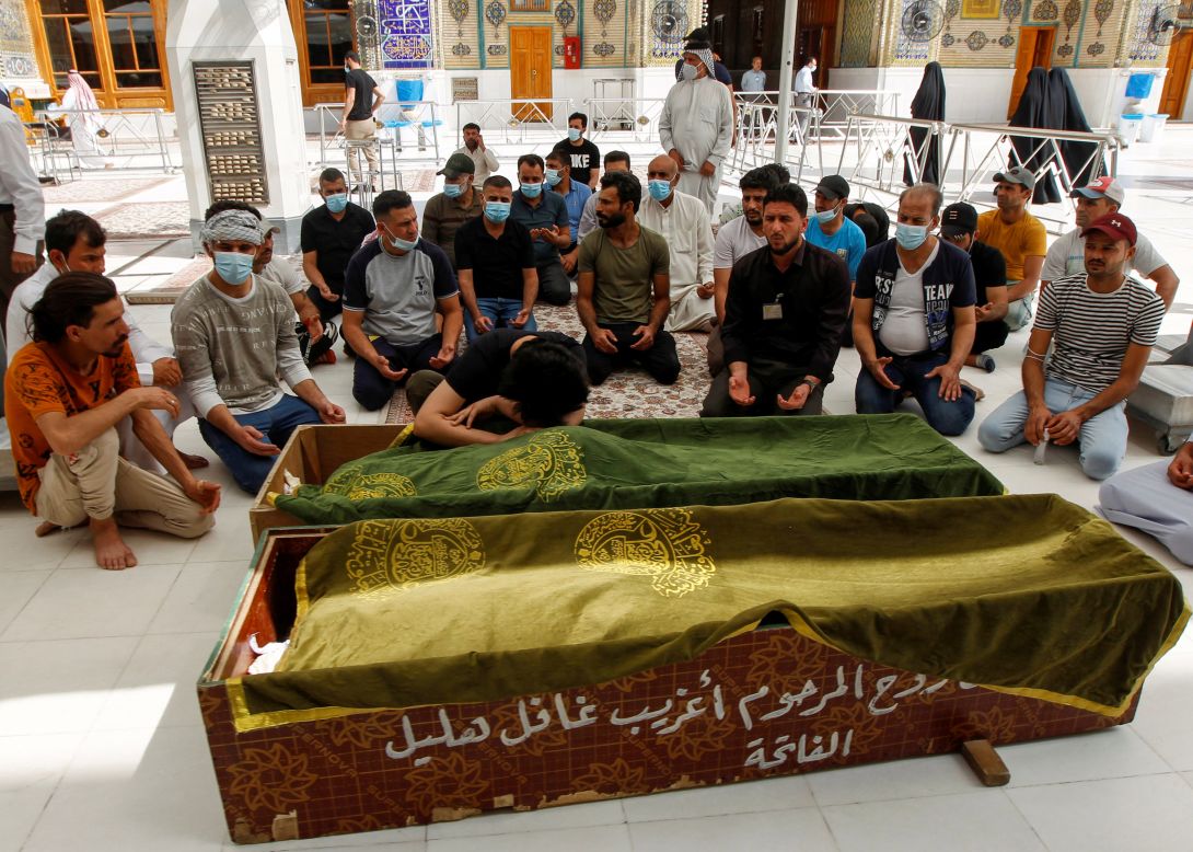 People in Najaf, Iraq, pray next to the coffins of people who were among those killed in a <a href="https://www.cnn.com/2021/04/24/middleeast/baghdad-hospital-fire-oxygen-tanks-explosion-intl/index.html" target="_blank">huge hospital fire</a> in the capital city of Baghdad on Saturday, April 24. At least 82 people died in the fire, which was believed to have started after oxygen tanks exploded, according to two health officials at the Ibn al-Khatib Hospital.