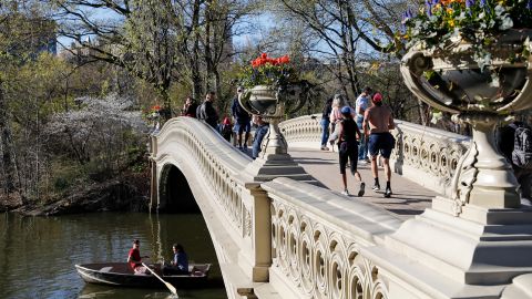 People stand on the Bow Bridge at Central Park on April 13 in New York City. The city is targeting a July 1 reopening.