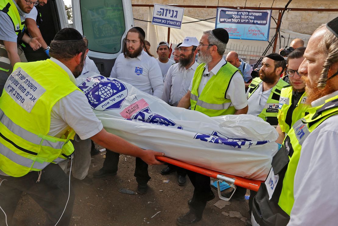 Israeli rescue teams carry a body into an ambulance on Friday at Mount Meron.