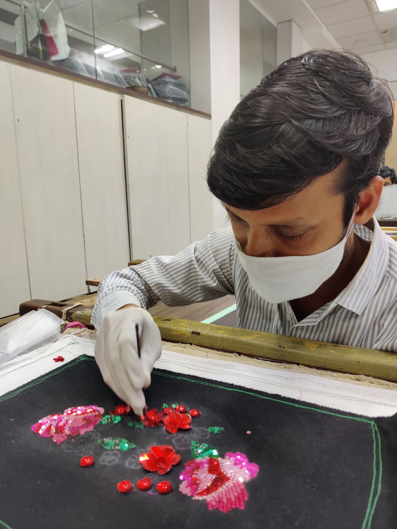 A craftsman works on a face mask at Milaaya Embroideries. Amid disappearing orders from luxury labels, the company has had to find new ways to generate income and pay employees.