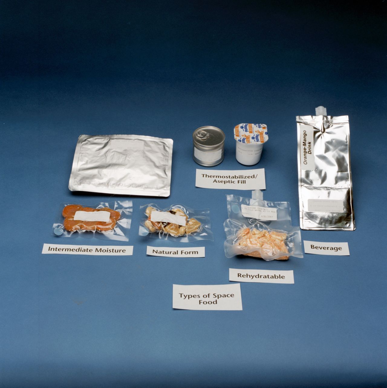 Space Shuttle astronaut diets were designed to supply each crew member with all the recommended dietary allowances of vitamins and minerals necessary to perform in the environment of space. Food shown here includes packaged orange-mango beverage and rehydratable shrimp cocktail.