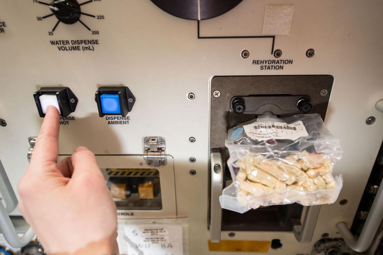 European Space Agency astronaut Samantha Cristoforetti prepares her lunch using the space food rehydrator aboard the International Space Station.
