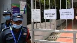 Security guards stand next to signs announcing that vaccines are out of stock outside a Covid-19 coronavirus vaccination centre closed for three days due to shortage of vaccine supplies, in Mumbai on April 30, 2021.