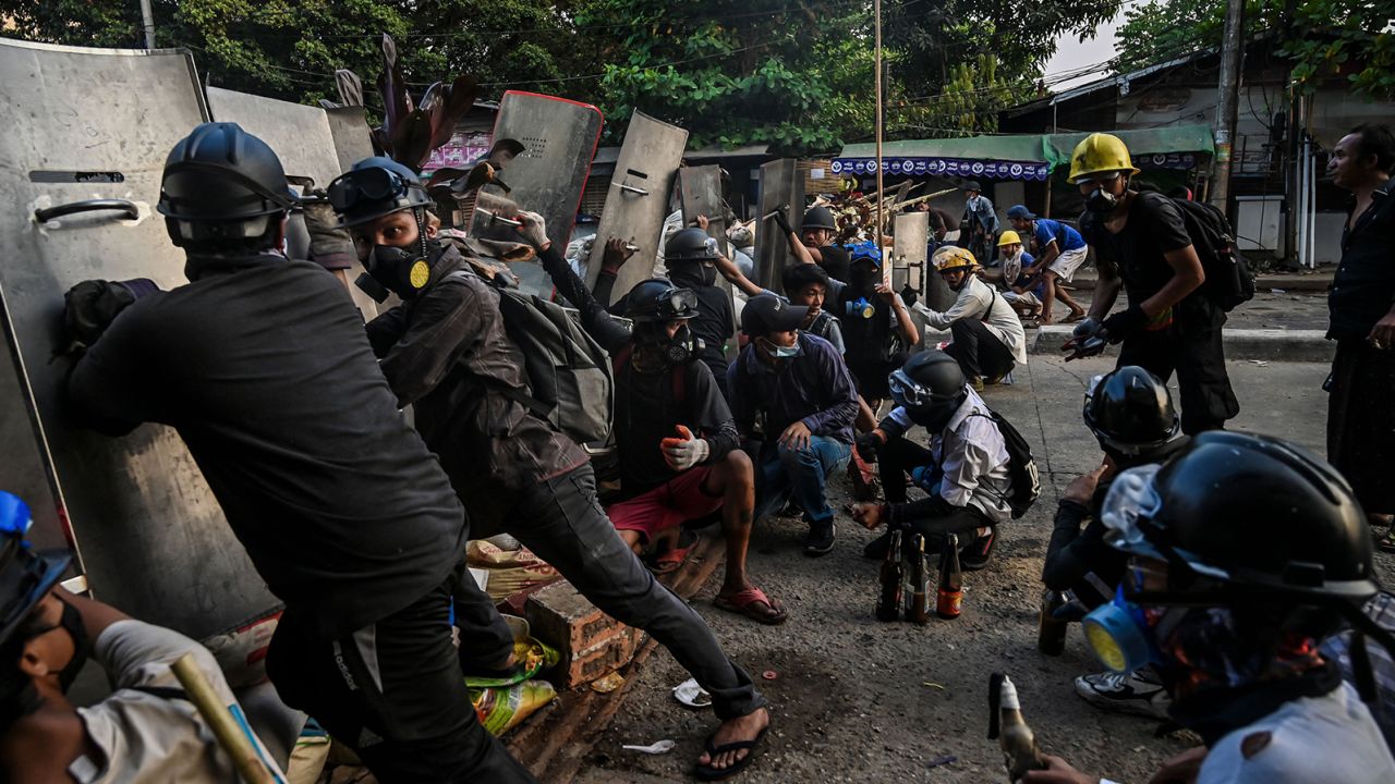 Protesters take cover behind homemade shields as they confront the police during a crackdown on demonstrations against the military coup in Yangon on March 16.