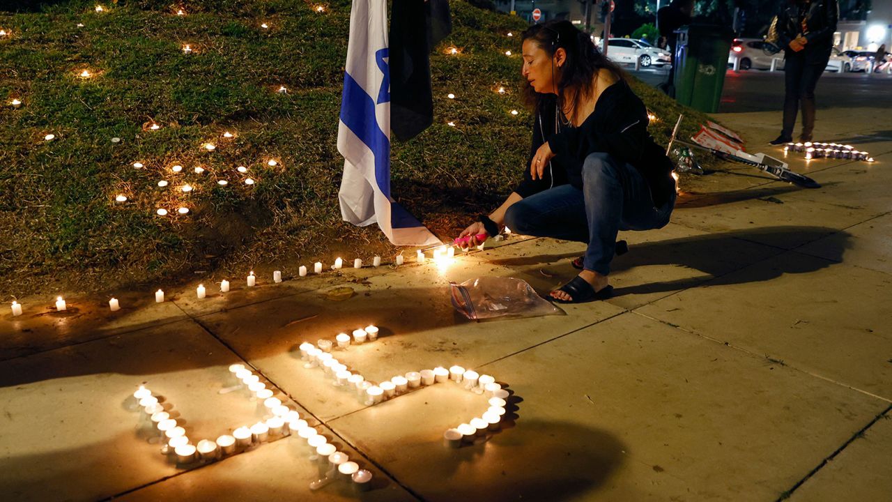 People light candles during a vigil in Habima Square in the Israeli coastal city of Tel Aviv on May 1, 2021.