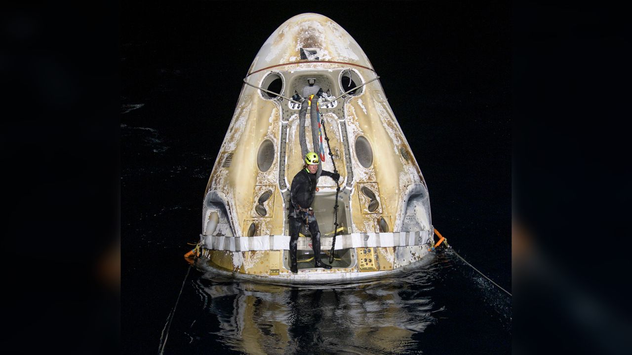 Support teams work around the SpaceX Crew Dragon Resilience spacecraft shortly after it landed