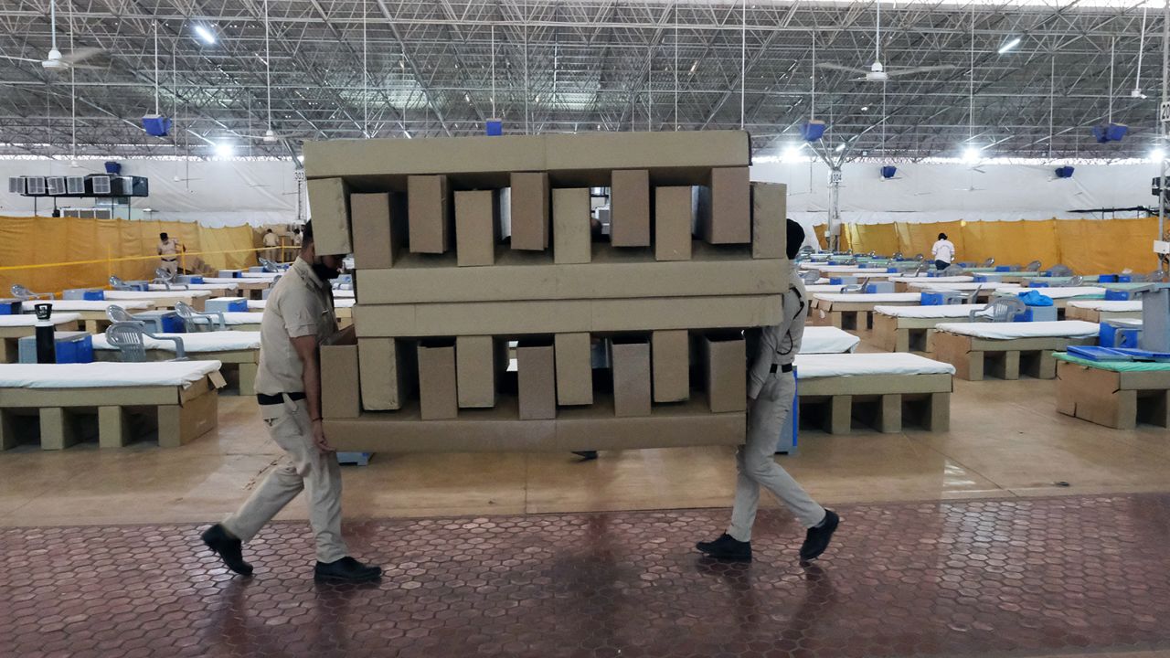 Workers carry biodegradable cardboard beds in a makeshift ward at the Sardar Patel Covid Care Centre and Hospital in New Delhi, India, on April 24, 2021.