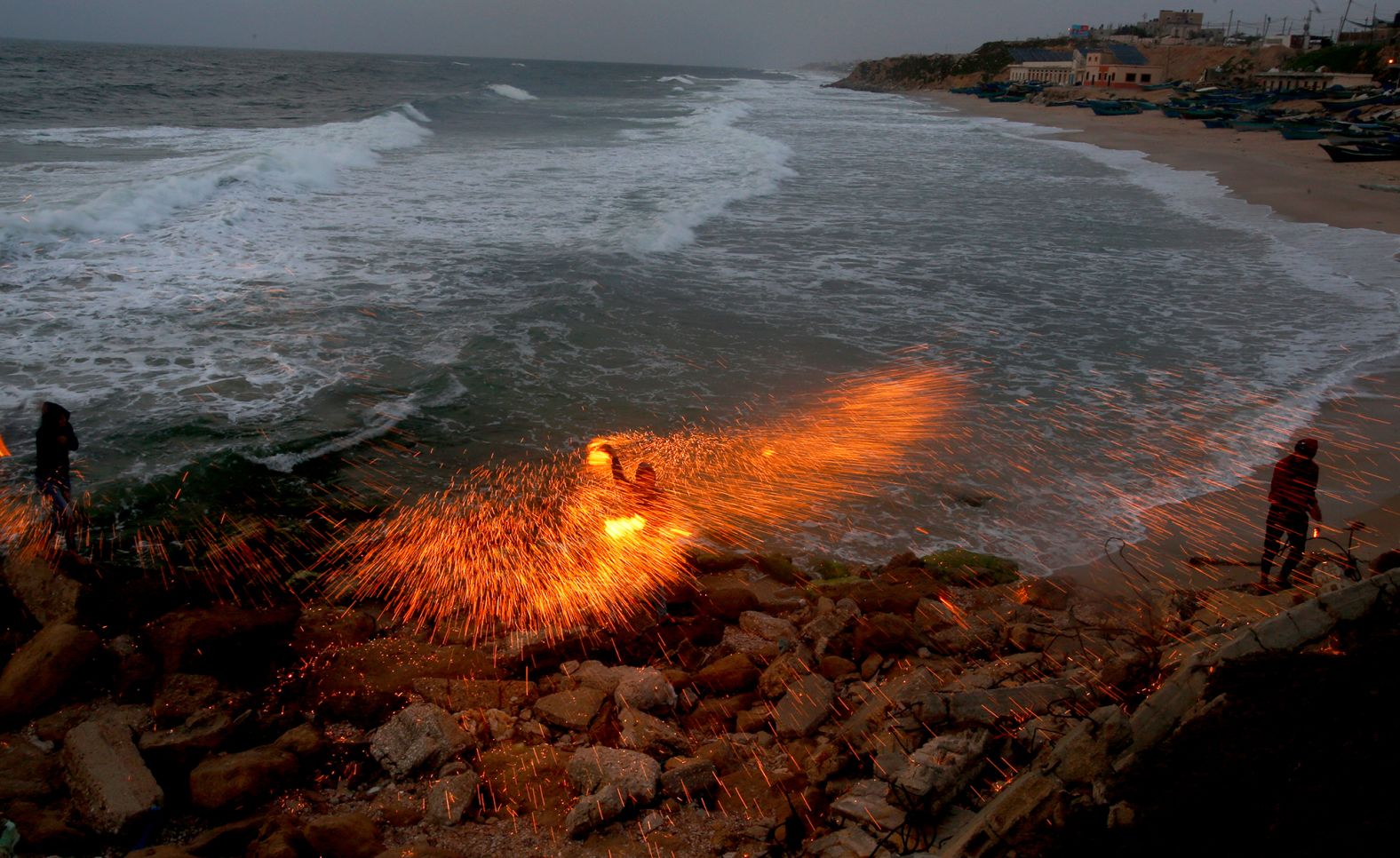A man swings sparkler fireworks on a beach in Gaza City on April 26.