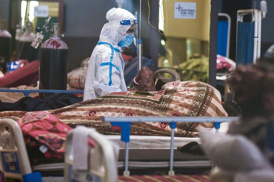 A health worker wearing a personal protective equipment suit attends a patient inside a banquet hall temporarily converted into a Covid-19 coronavirus ward in New Delhi on May 1, 2021. 