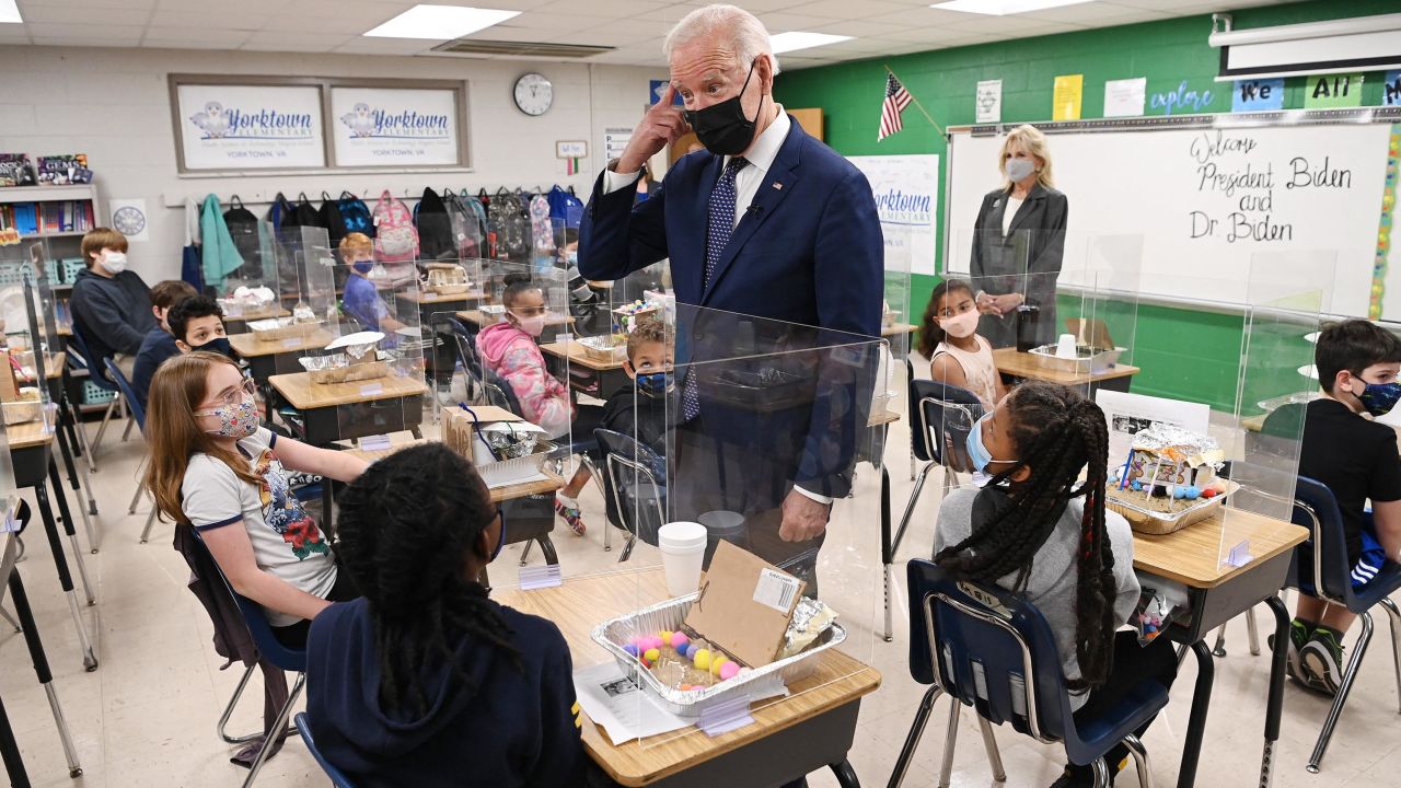 US President Joe Biden  points to his hair after a student told him she wanted to be a hairstylist when she grows up, as he and First Lady Jill Biden visit Yorktown Elementary School in Yorktown, Virginia on May 3, 2021. 