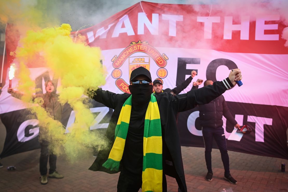 Fans are seen protesting Manchester United's Glazer ownership outside the stadium.