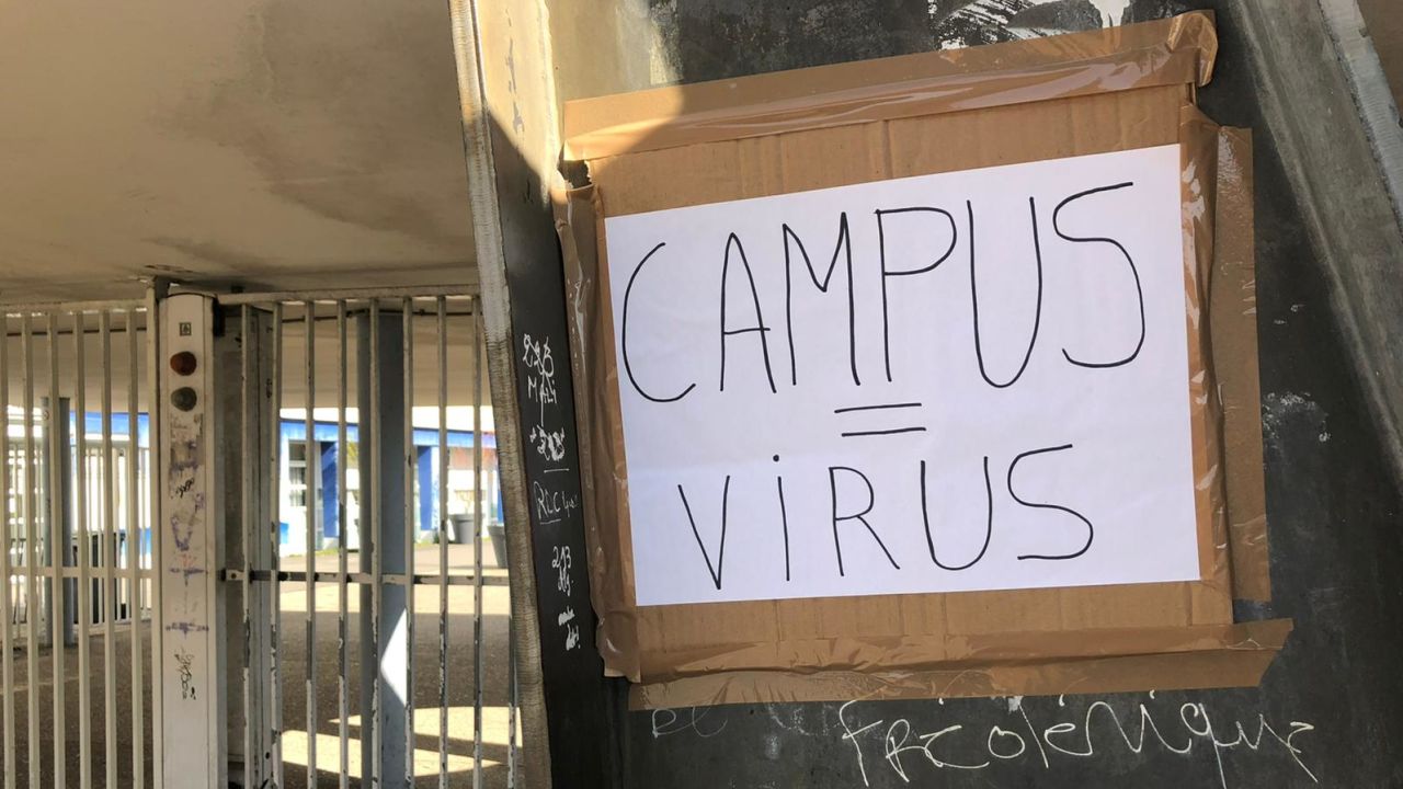 A handwritten placard reading "Campus = Virus" at Eugene Delacroix high school.