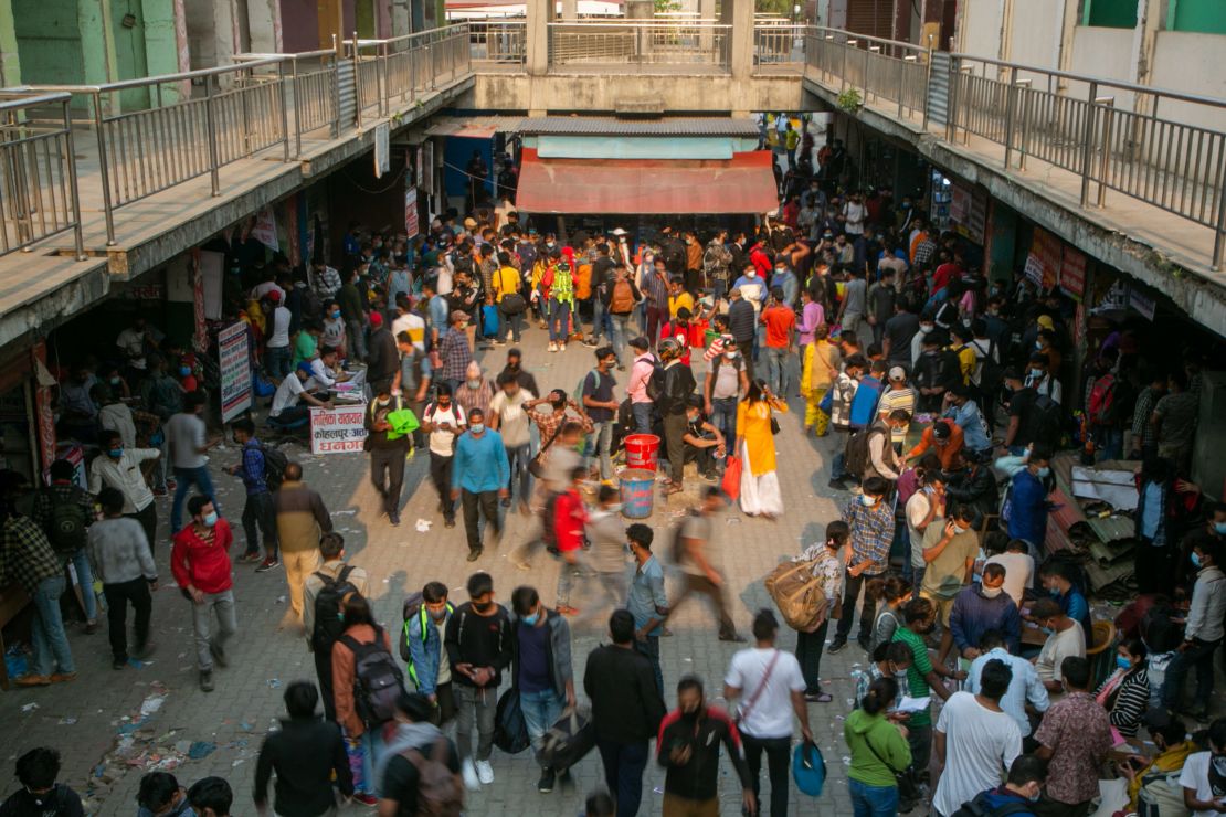 Nepali people arrive at a crowded bus station to buy bus tickets to go back to their villages a day prior to lockdown in Kathmandu, Nepal, on April 28, 2021. 