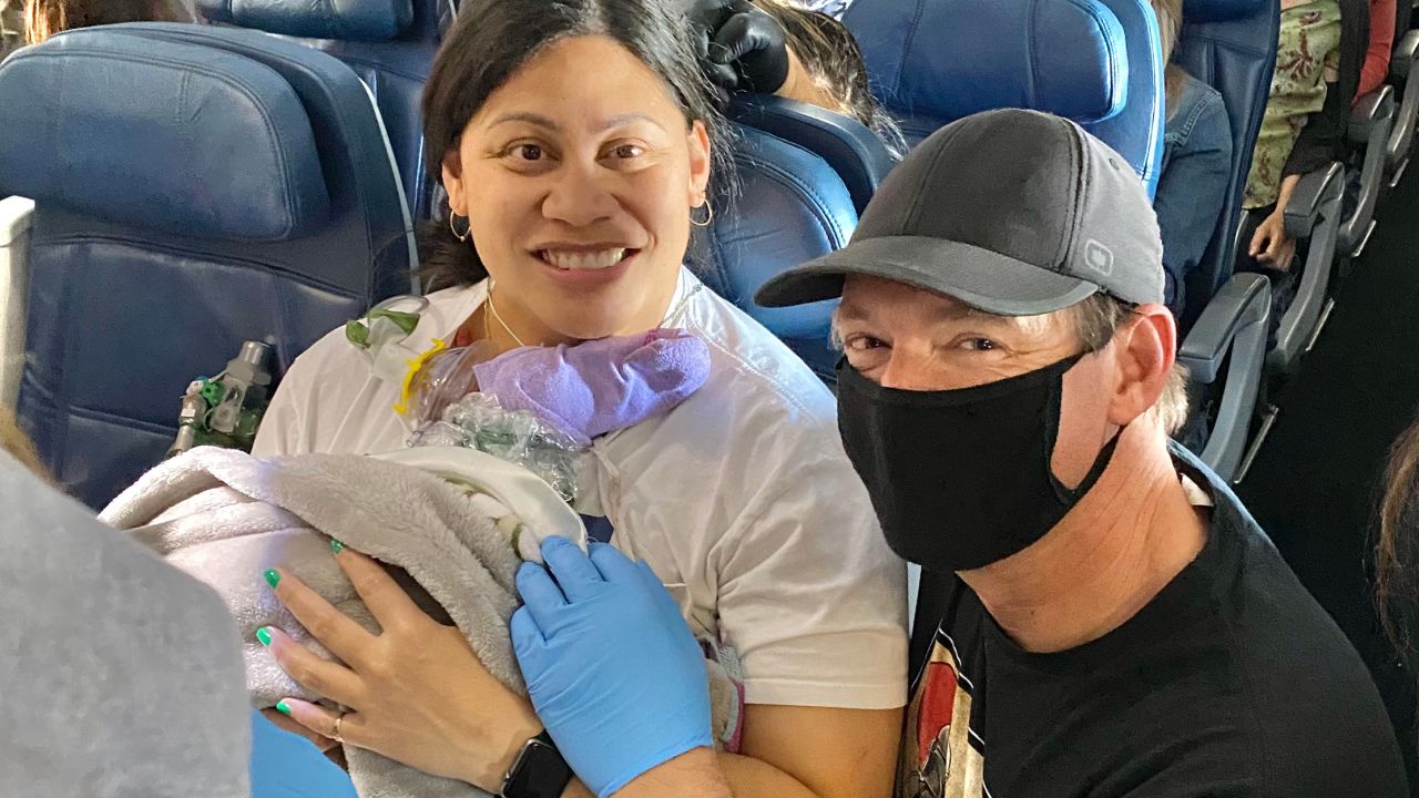 Dr. Glenn poses for a picture with Lavi Mounga and baby Raymond before leaving the plane.