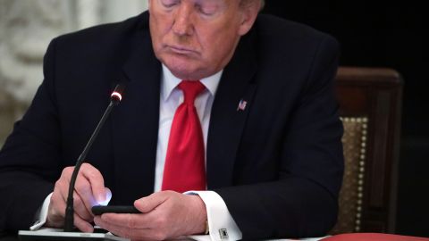 Former president Donald Trump works on his phone during a roundtable at the State Dining Room of the White House June 18, 2020 in Washington, DC. 