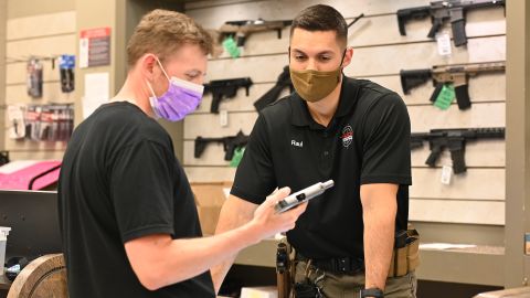 A prospective customer inspects a handgun at Maxon Shooter's Supplies & Indoor Range in Des Plaines, Illinois.