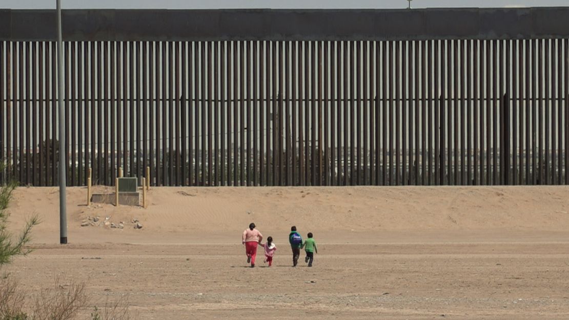 A woman and three young children race toward the wall at the US-Mexico border in Ciudad Juárez, Mexico. They were detained by US Border Patrol a few minutes later.