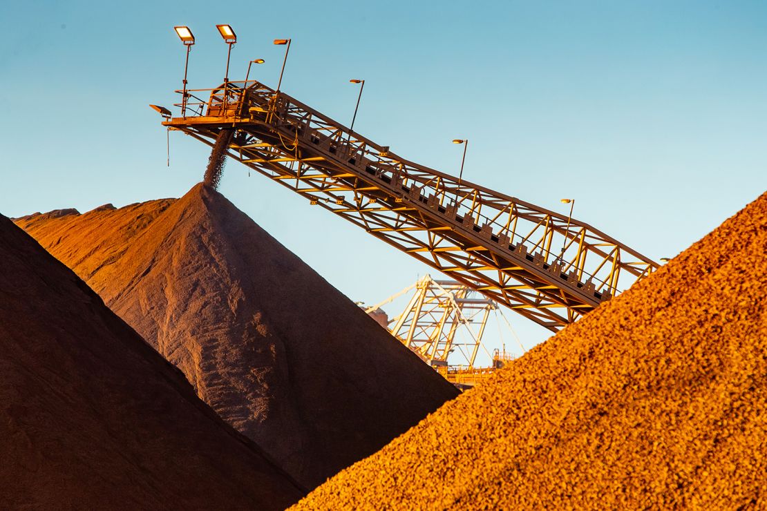 Iron ore falls from a conveyor to a stockpile at the port in Port Hedland, Australia, on Monday, March 18, 2019.