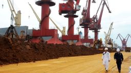 Chinese inspectors walk past piles of rare earth on a quay at the Port of Lianyungang in Lianyungang city, east China's Jiangsu province, 22 May 2016.