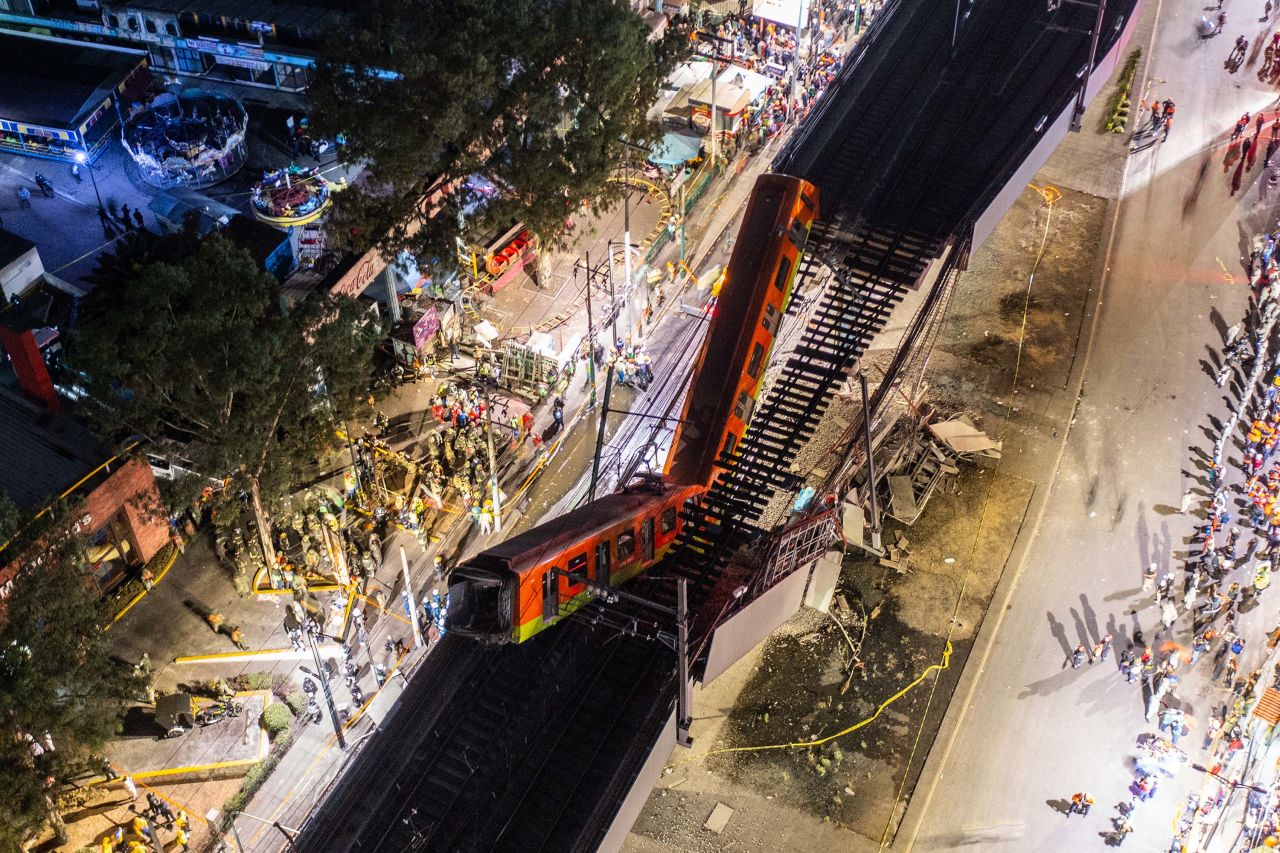 Rescue efforts were temporarily suspended Monday night due to concerns over a subway car dangling over the road.