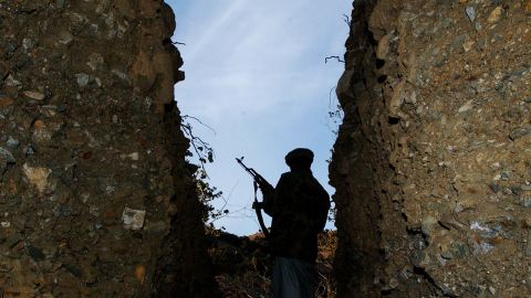 A fighter stands guard over a cave in Tora Bora, Afghanistan, during a clearance operation by US forces and allies in December 2001. 