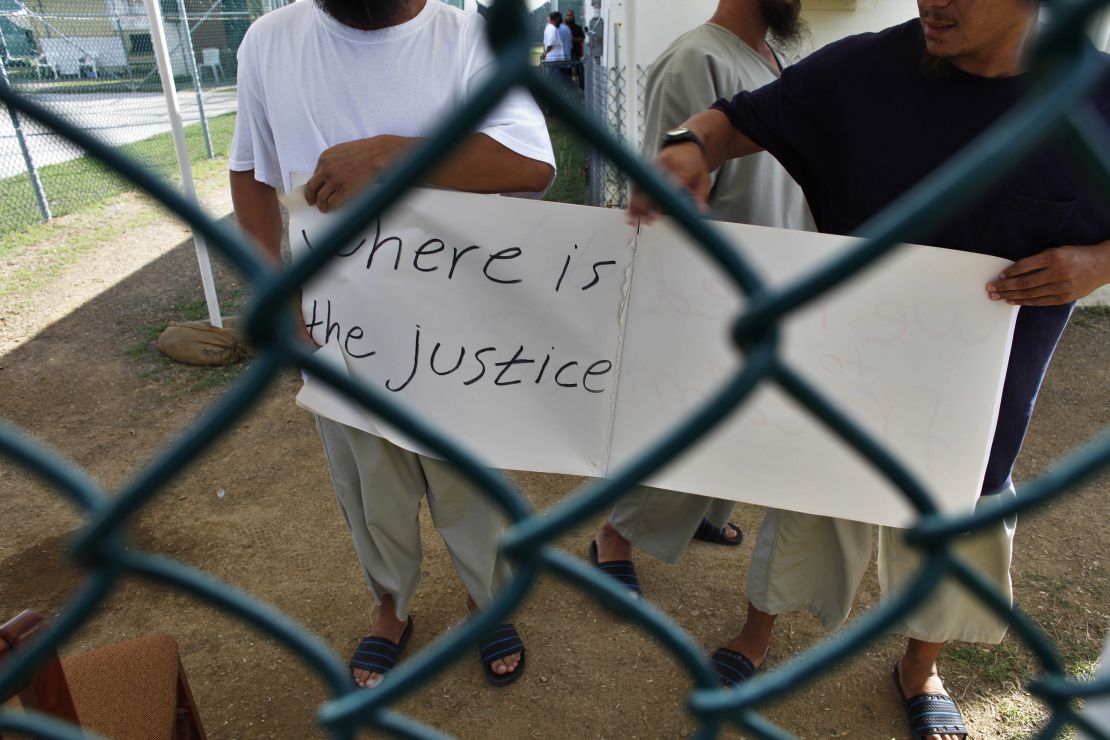 Uyghur detainees at Guantanamo Bay hold a sign calling for their release during a visit by reporters in 2009.