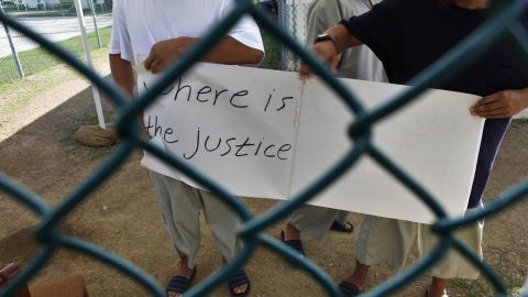 Uyghur detainees at Guantanamo Bay hold a sign calling for their release during a visit by reporters in 2009.