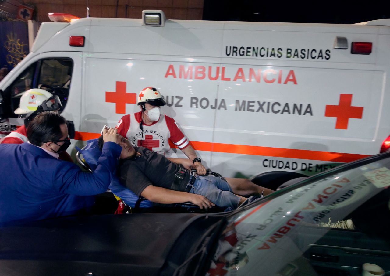 Members of the Mexican Red Cross transport an injured person on a stretcher.