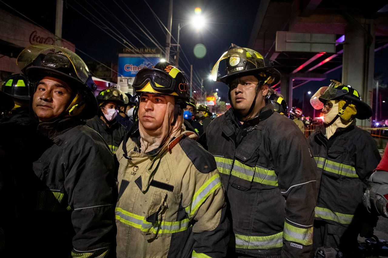 Rescue workers stand at the scene of the collapse.