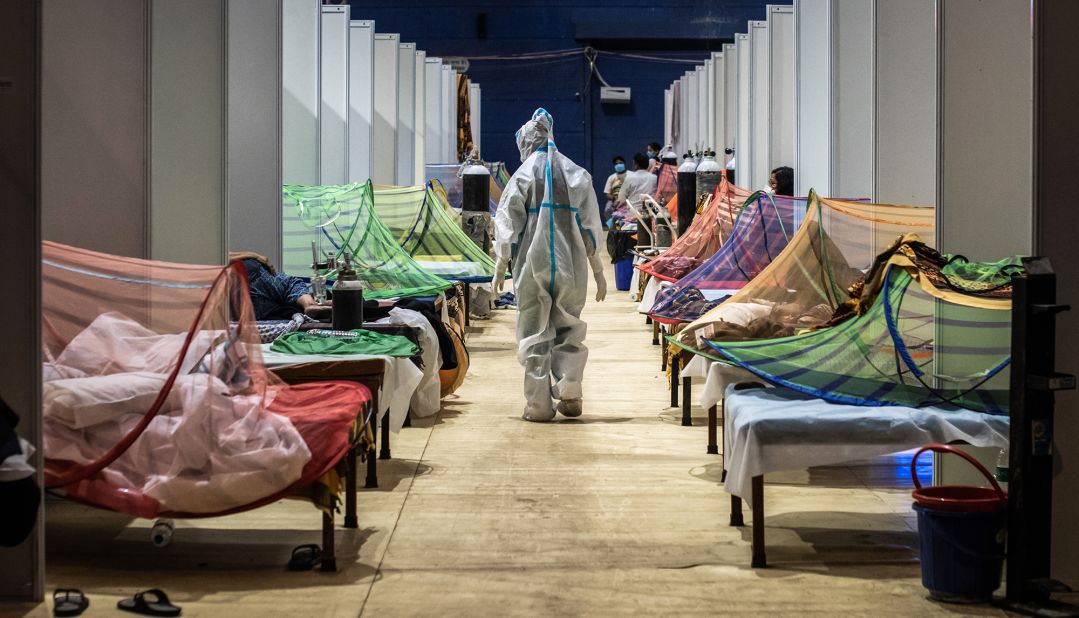 A medical worker observes patients inside a Covid-19 ward that was set up inside a sports stadium in New Delhi.