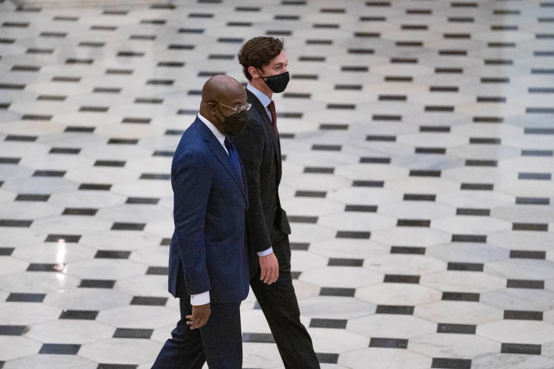 Sens. Raphael Warnock and Jon Ossoff of Georgia walk toward the House Chamber in National Statuary Hall of the US Capitol on April 28, 2021.