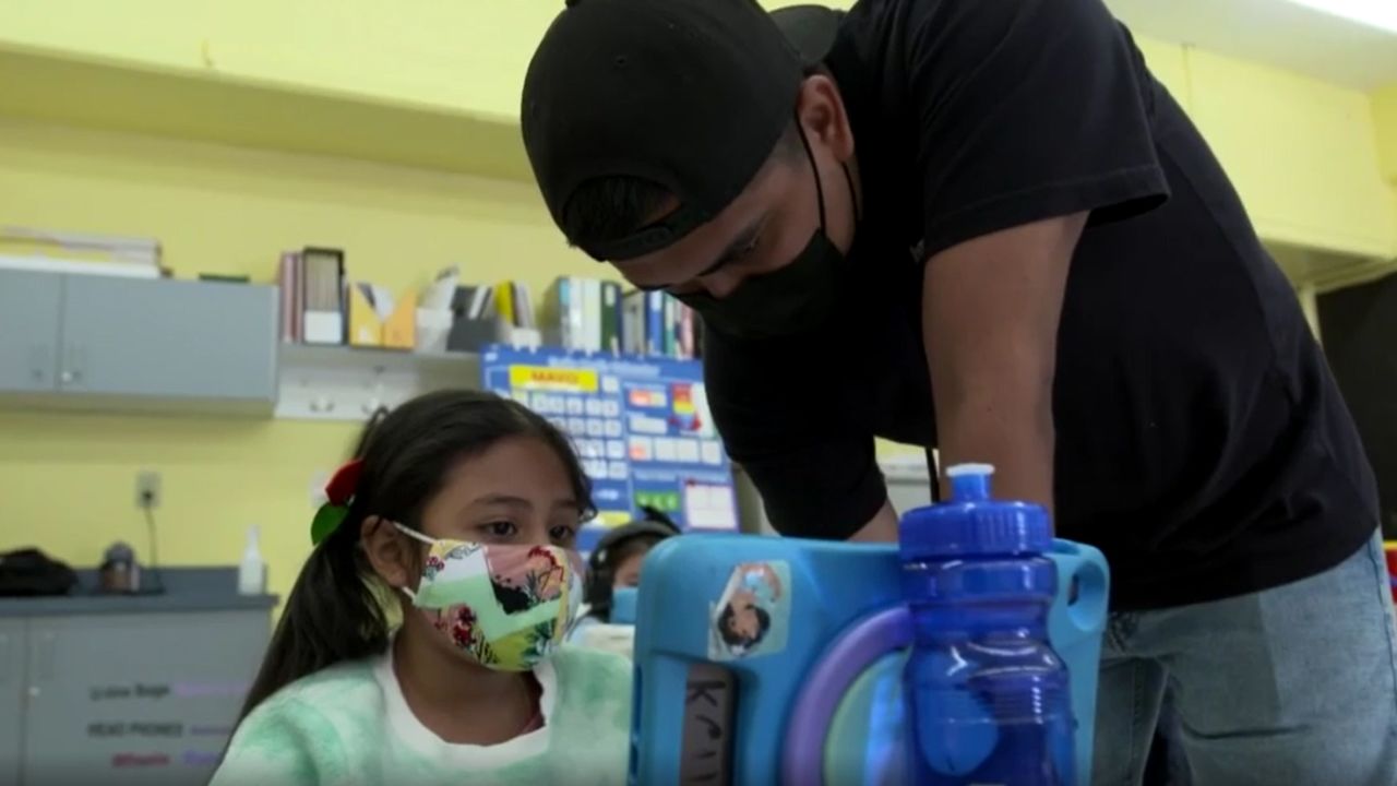 A student and staff member work at a Boys and Girls Clubs of the Peninsula in Palo Alto, CA. The entire staff will be required to be vaccinated by mid-June.