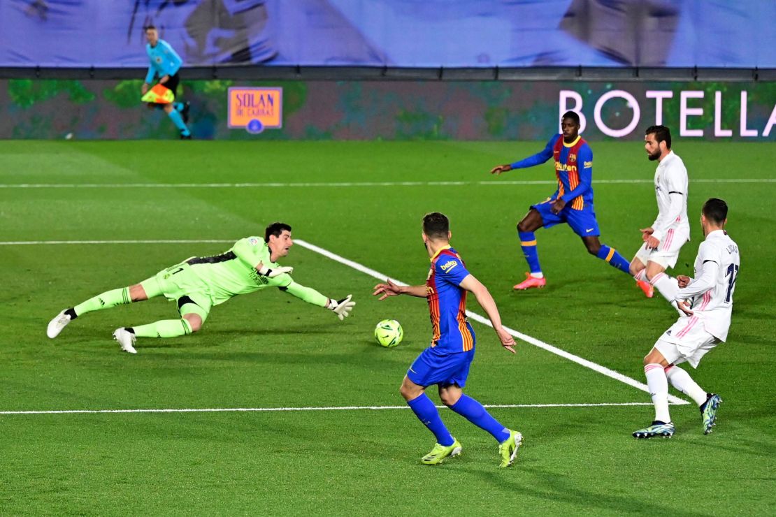 Courtois dives for the ball during the El Clasico between Real Madrid and Barcelona.