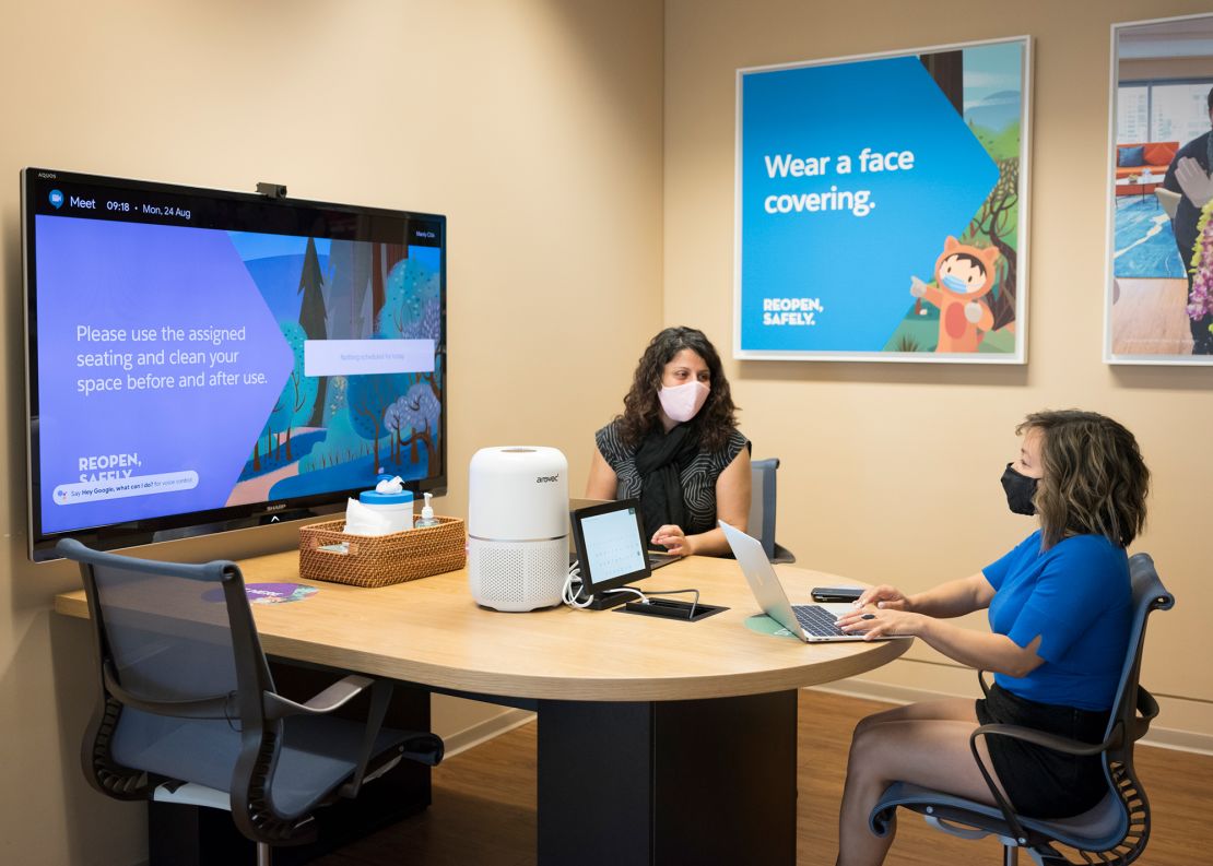 Salesforce employees in Sydney work in a conference room with new safety protocols.