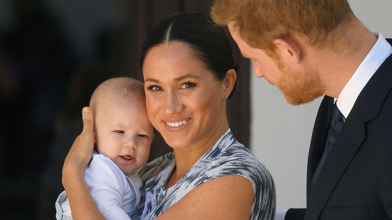 Meghan smiles while holding Archie alongside Harry during their trip to Cape Town, South Africa, on September 25, 2019.