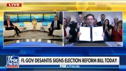 Florida Gov. Ron Desantis holds up the voting bill after signing it on Fox News live. The cable news network was the only press outlet granted access to the signing.