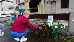 A woman lays flowers outside the house where a 31-year-old French mother of three was burned alive by her husband, on May 5, 2021 in Merignac. - The man chased her down the street and shot her in the legs before dousing her in a flammable liquid and setting her alight. He was arrested half an hour after the murder in the neighbouring district of Pessac, armed with a pistol, a pellet gun and a cartridge belt, the Bordeaux prosecutor's office said. (Photo by MEHDI FEDOUACH / AFP) (Photo by MEHDI FEDOUACH/AFP via Getty Images)