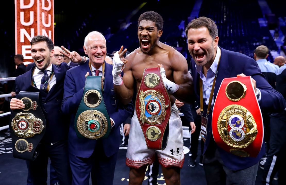 Anthony Joshua poses for a photo with the IBF, WBA, WBO & IBO World Heavyweight Title belts with Eddie Hearn and Barry Hearn after bout against Andy Ruiz Jr. at the Diriyah Season on December 07, 2019 in Diriyah, Saudi Arabia.