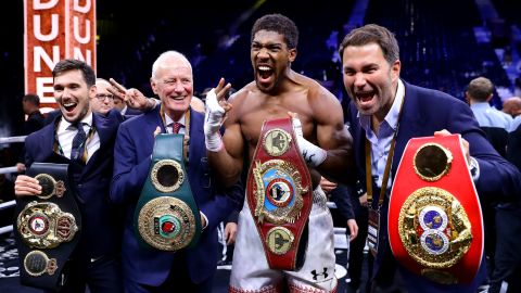 Anthony Joshua poses for a photo with the IBF, WBA, WBO & IBO World Heavyweight Title belts with Eddie Hearn and Barry Hearn after bout against Andy Ruiz Jr. at the Diriyah Season on December 07, 2019 in Diriyah, Saudi Arabia.