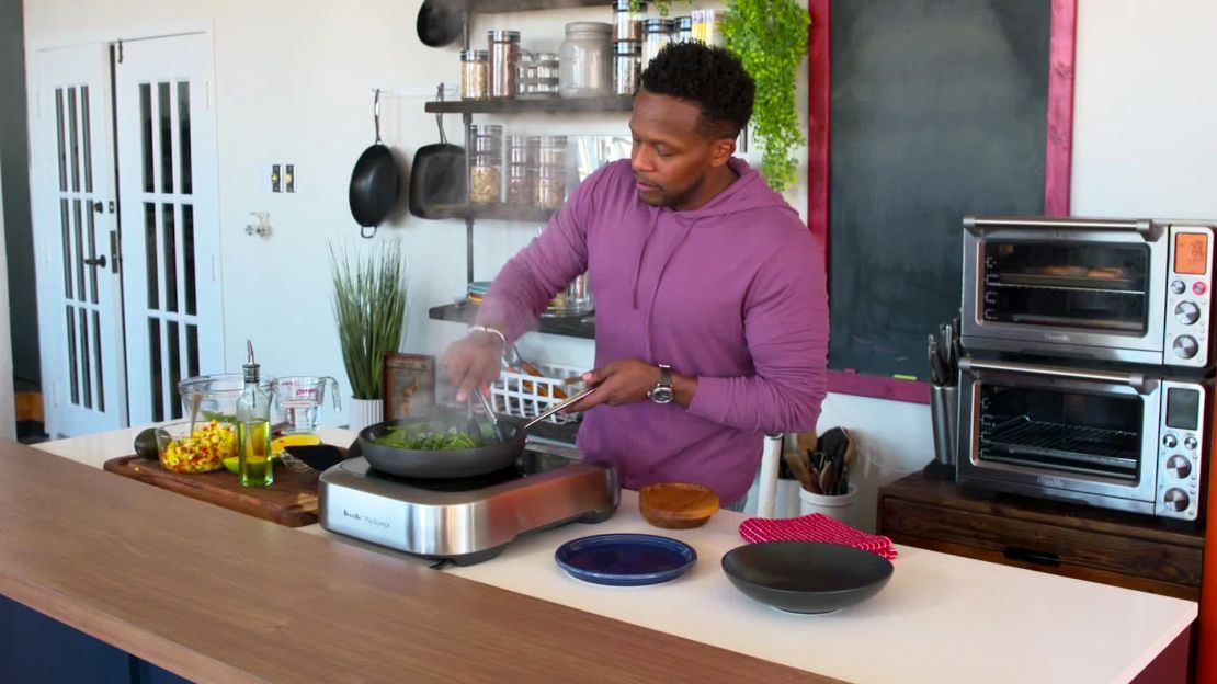 Curry prepares salmon with spinach, cauliflower rice and mango salsa in his Dallas test kitchen.